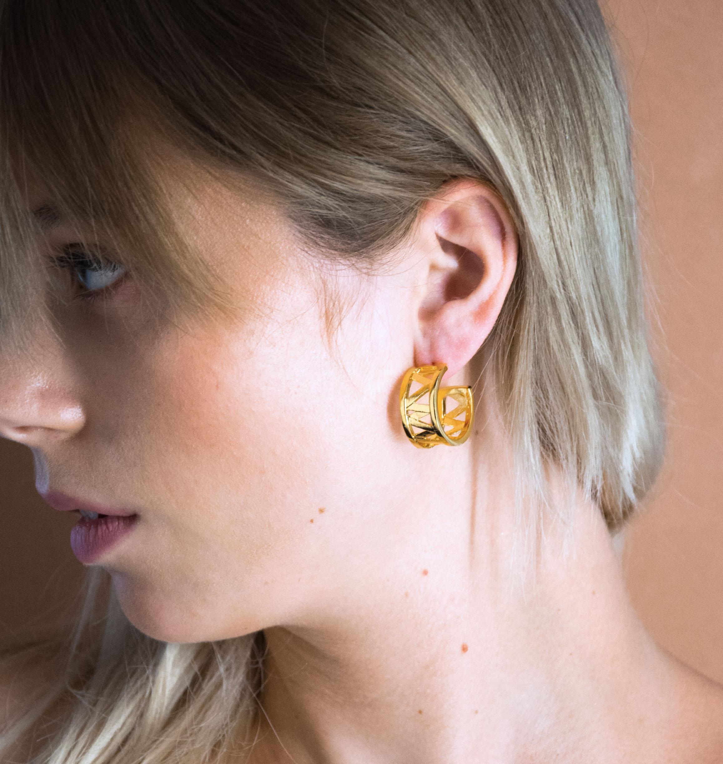 Nos boucles d'oreilles CHARMY sont réalisées en bronze dorées à l'or fin. Elegantes et minimales, elles perfectionneront votre style avec une touche de modernité et seront assez discrètes pour être associées à vos tenues du quotidien , bijoux doré or, bijoux créateurs fabriqué made in Belgium , boucle d'oreille originale, boucle d'oreille or doré,