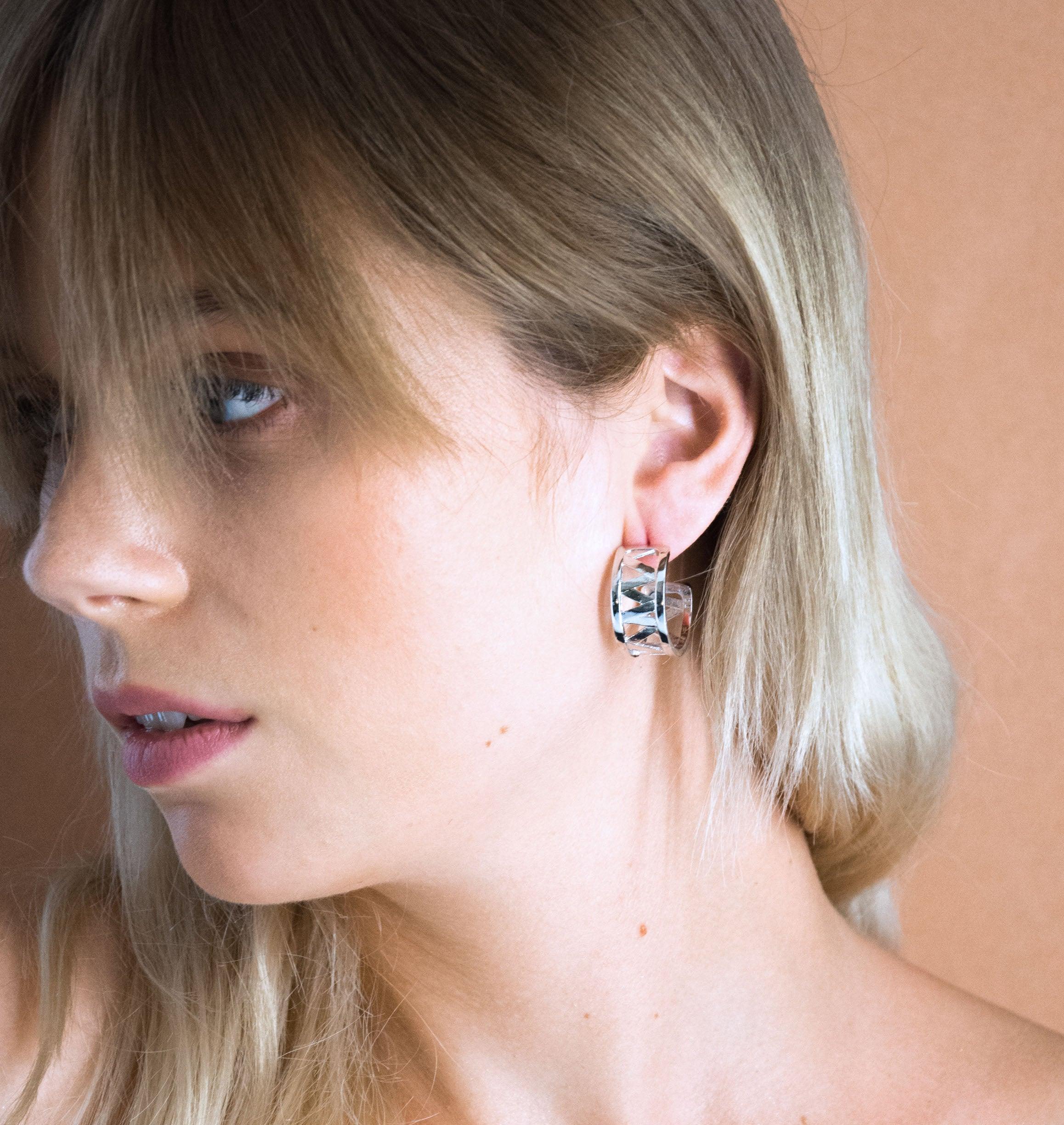 Nos boucles d'oreilles CHARMY sont réalisées en bronze argenté. Elegantes et minimales, elles perfectionneront votre style avec une touche de modernité et seront assez discrètes pour être associées à vos tenues du quotidien. bijoux argenté argent, bijoux créateurs fabriqué made in Belgium , boucle d'oreille originale, boucle d'oreille argent argenté