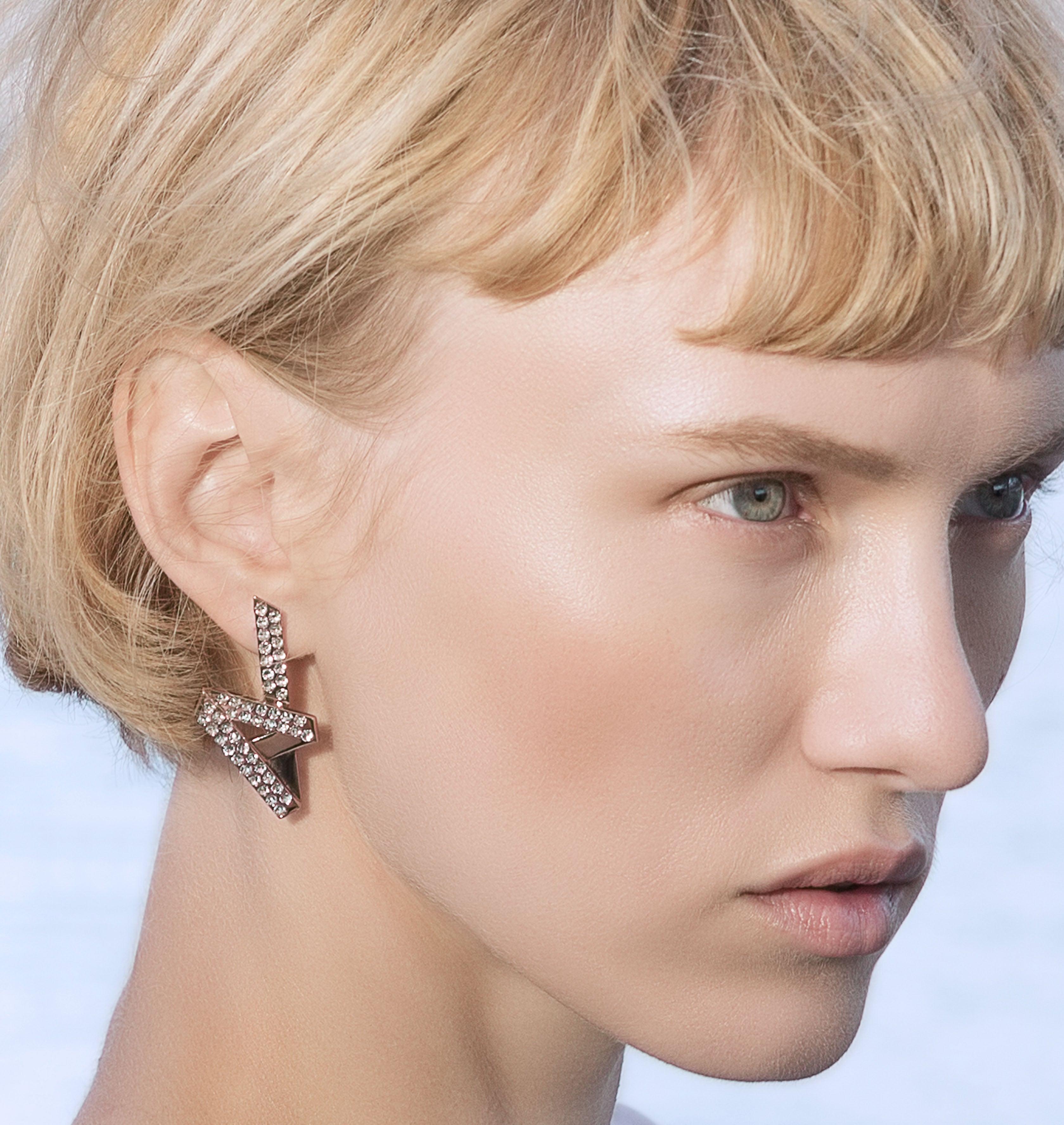 Moutton colleT Nos boucles d'oreille CRYSTAL VIBES sont réalisées en bronze doré à l'or rose fin, serties de cristaux scintillants coloris diamond. Elles donneront à votre look une touche fun et chic. bijoux rose or, bijoux créateurs fabriqué made in Belgium , boucle d'oreille originale, boucle d'oreille or rose, zig zag, éclair. Strass , boucle d'oreille strass, année80