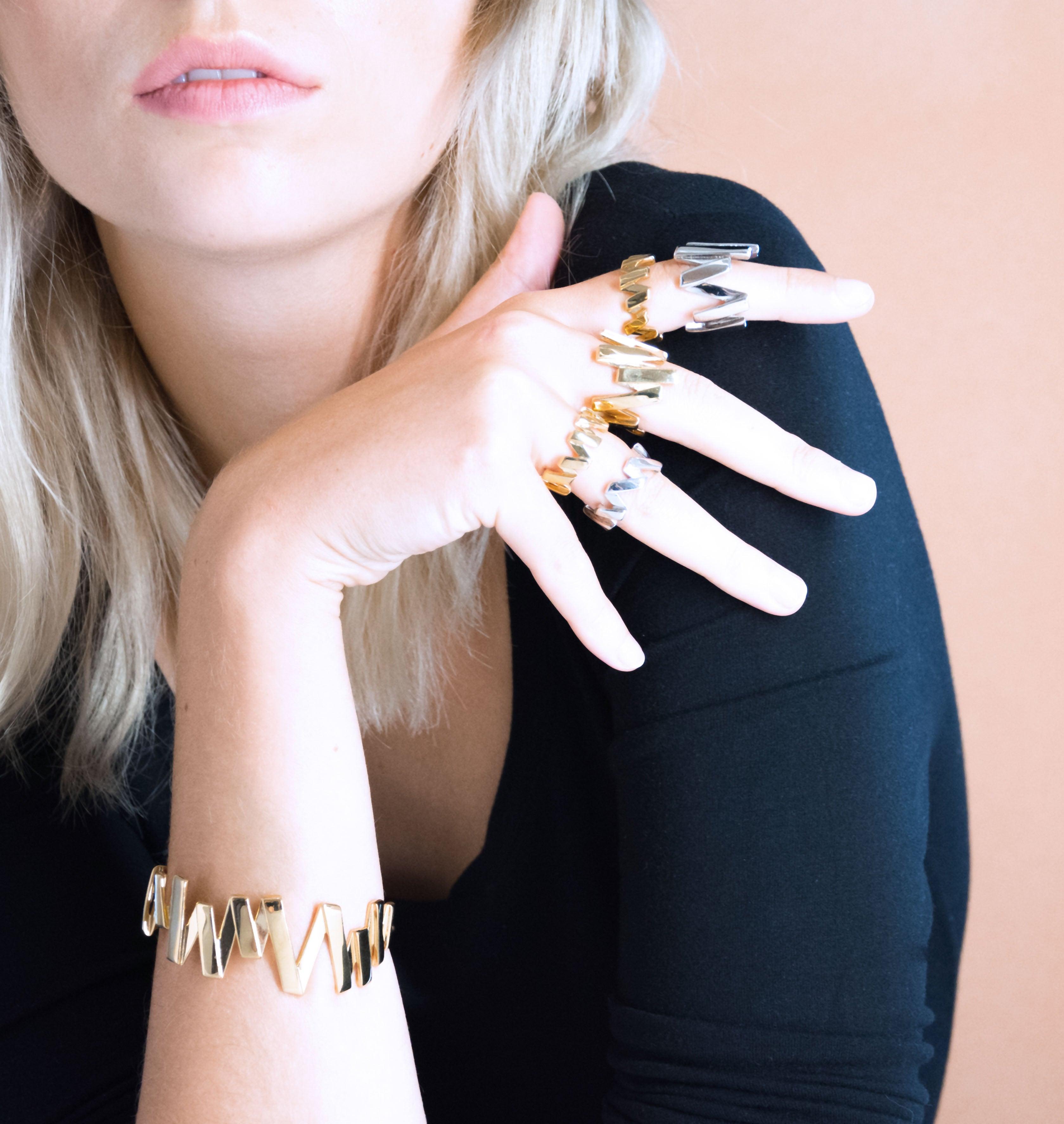 Moutton colleT Notre bracelet VIBRATIONS est réalisé en bronze doré à l'or fin. Il est orné d'un petit logo "MC". Il habillera votre poignet avec une touche fun et chic, pour un look modern et peps.bijoux doré or, bijoux créateurs fabriqué made in Belgium , bracelet originale, bracelet or doré, zig zag, éclair , bracelet année80