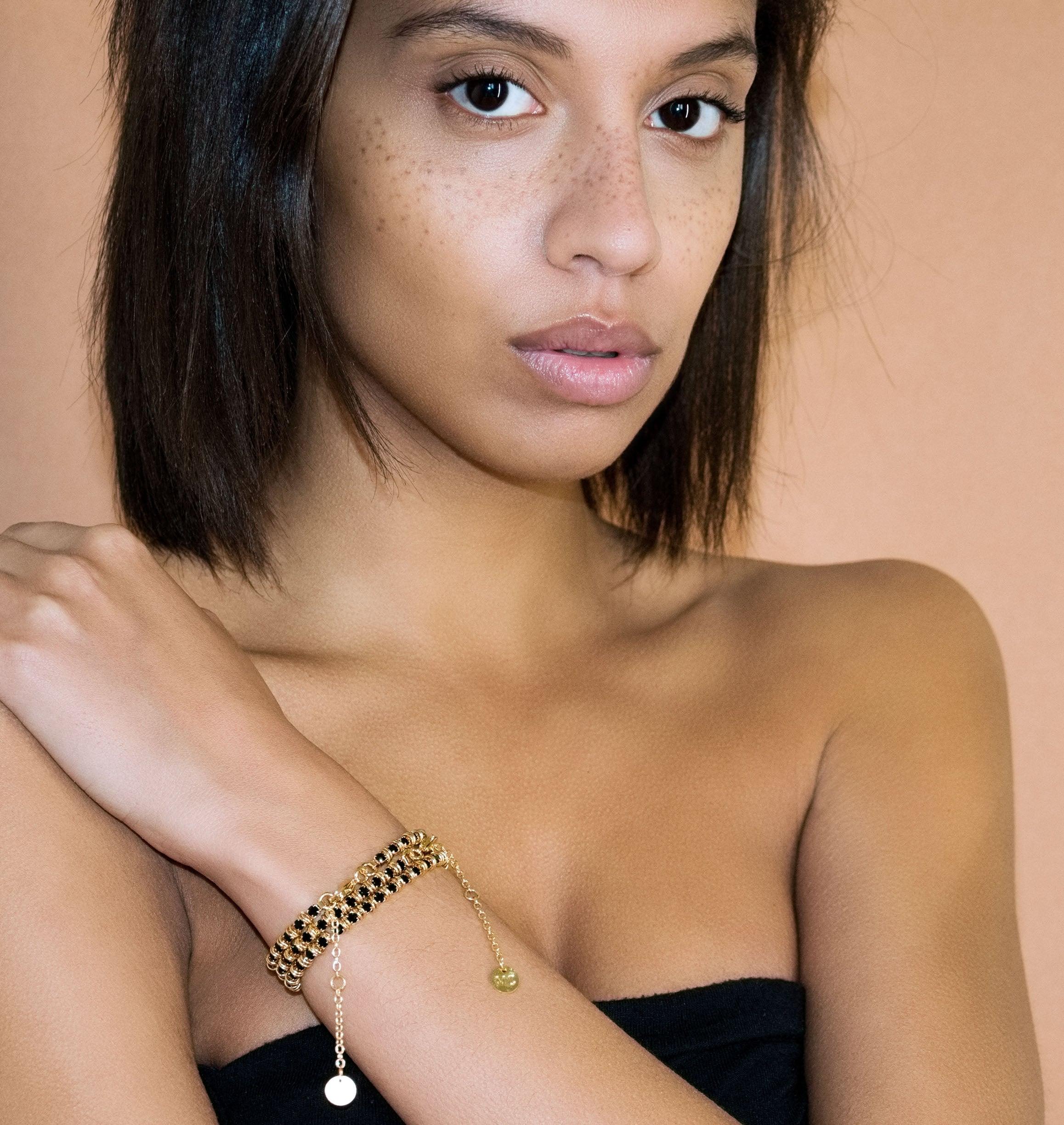 Bracelet LUCIOLE Black - shop.mouttoncollet.com, Moutton colleT Notre bracelet LUCIOLE est réalisé en bronze dorées à l'or fin, serties de cristaux scintillants coloris noir avec de grands anneaux. Il est orné d'un médaillon gravé "Moutton colleT" et d'un petit logo gravé "MC". Il sera assez discret pour être associé à vos tenues du quotidien.