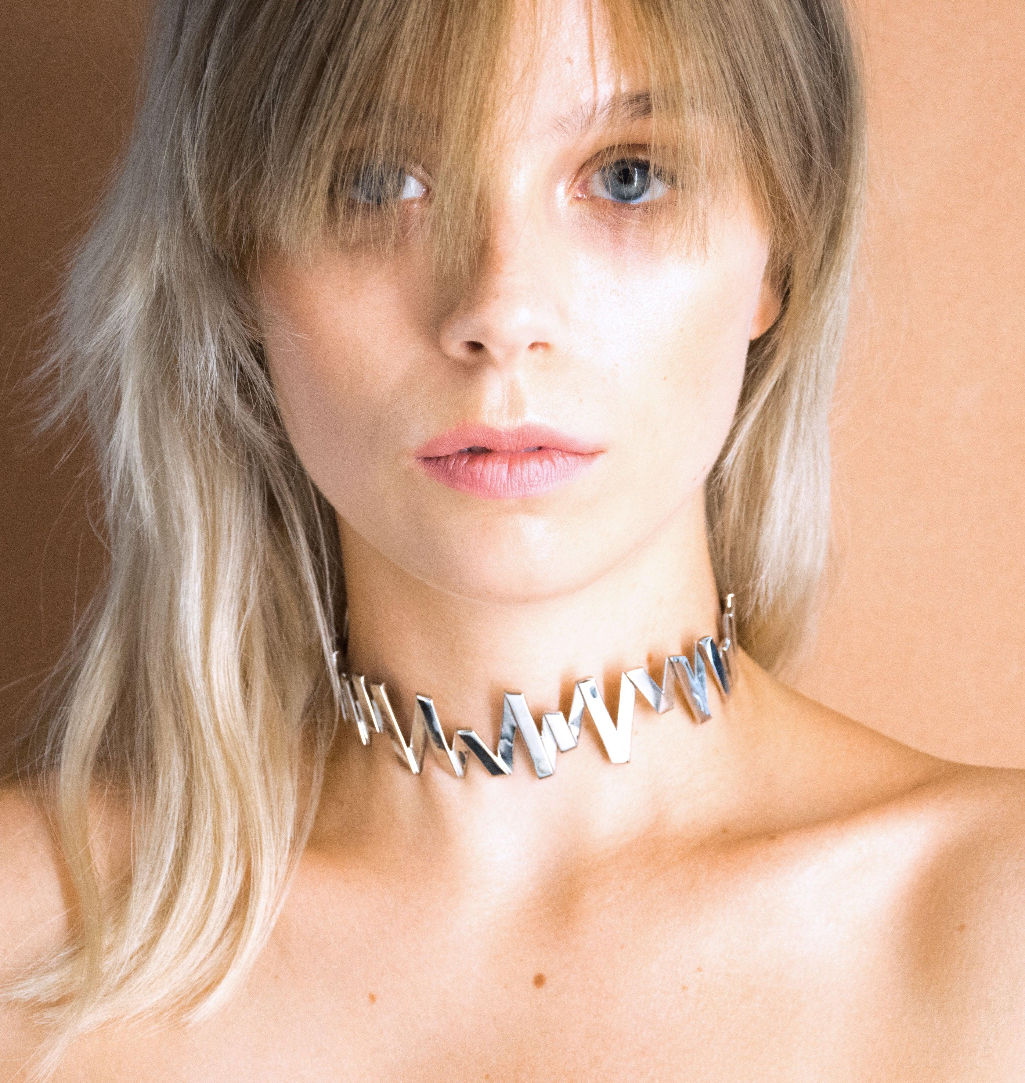 Moutton colleT Notre colier choker VIBRATIONS est réalisé en bronze argenté. Il est orné d'un petit logo "MC". Il habillera votre cou avec une touche fun et chic, pour un look modern et peps. bijoux argenté argent, bijoux créateurs fabriqué made in Belgium , choker originale, choker argent argenté, zig zag, éclair, choker, raz de cou, fabrication Belgique argent argenté, modern, collier raz de cou, collier choker, collier argent argenté, collier chaine